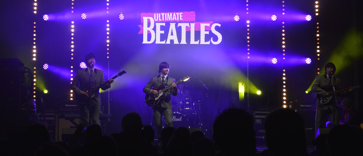 Beatles tribute band playing at a festival